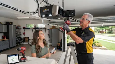 technician installing smart garage door opener with customer in Garland TX