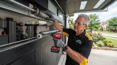 technician installing garage door opener and track in Garland TX
